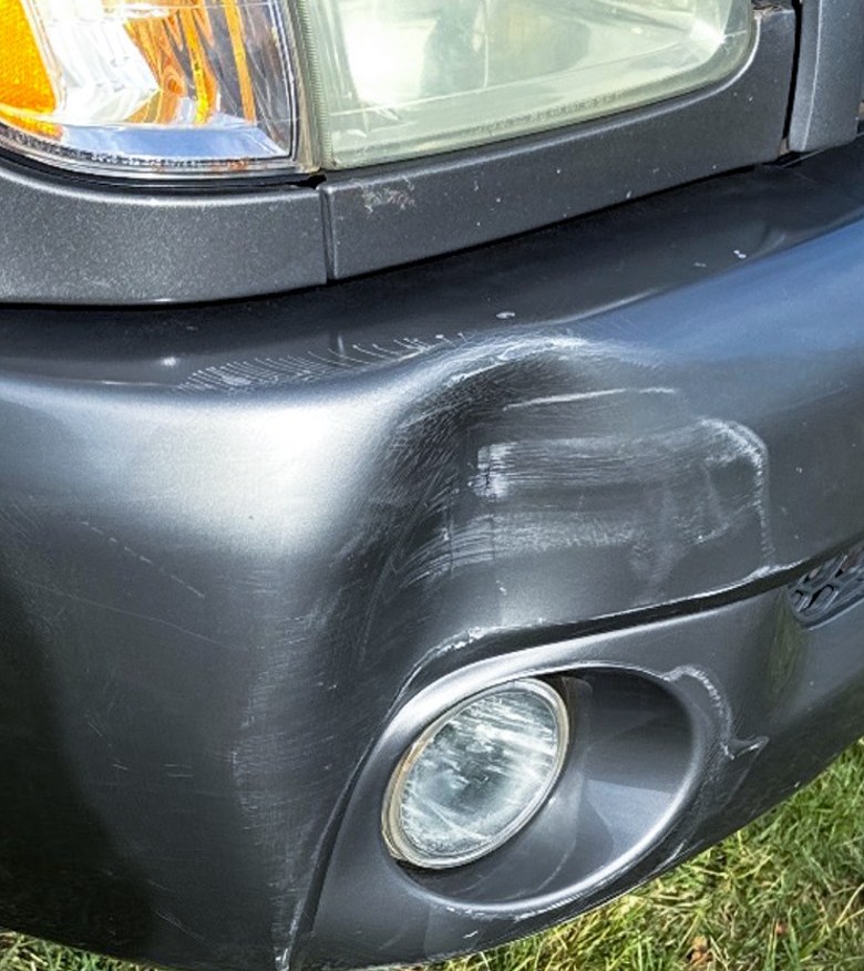 Truck bumper dent before paintless dent repair