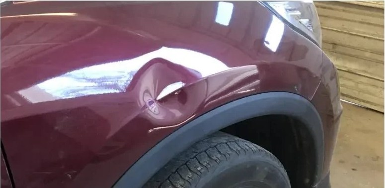 Maroon fender before paintless dent repair